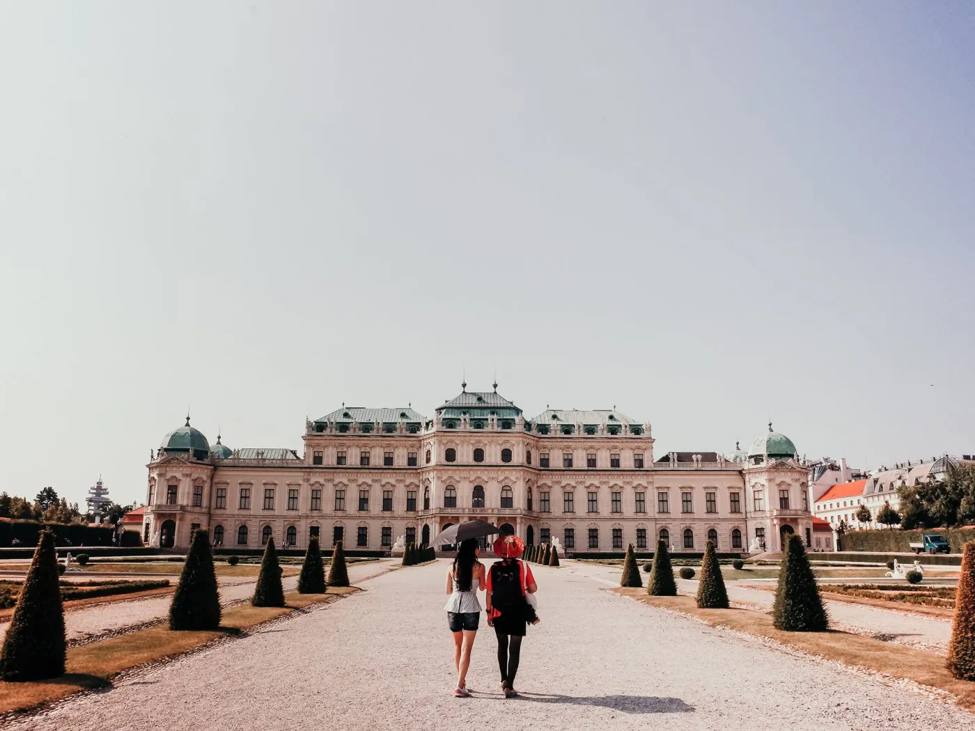 two people walk towards a large white building 1400x1050 1